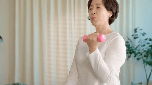 Woman exercising with dumbbells indoors