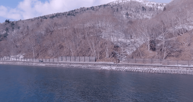 Narrow road below with snow-capped mountains in background