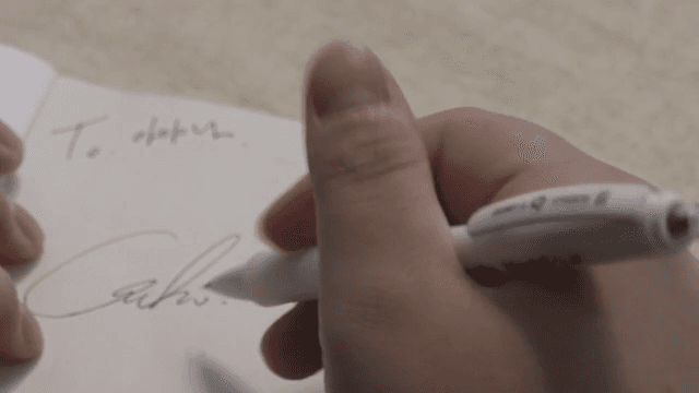 종이에 사인을 해주는 손