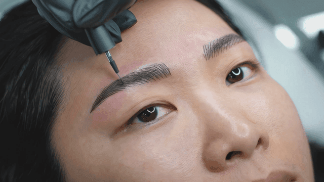 Woman undergoing eyebrow tattoo procedure