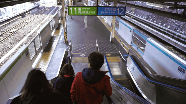 People descending an escalator at a train station