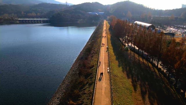 Straight walking path along lake and embankment