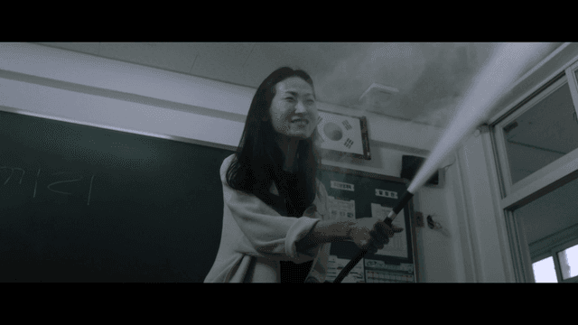 Woman angrily using fire extinguisher in classroom