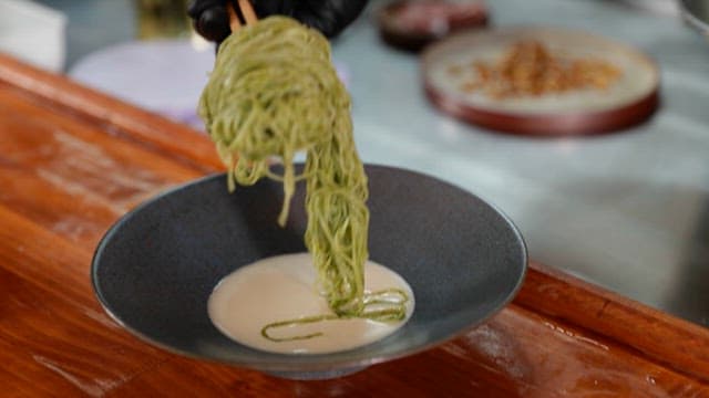 Preparing Green Noodles on Top of White Soybean Soup