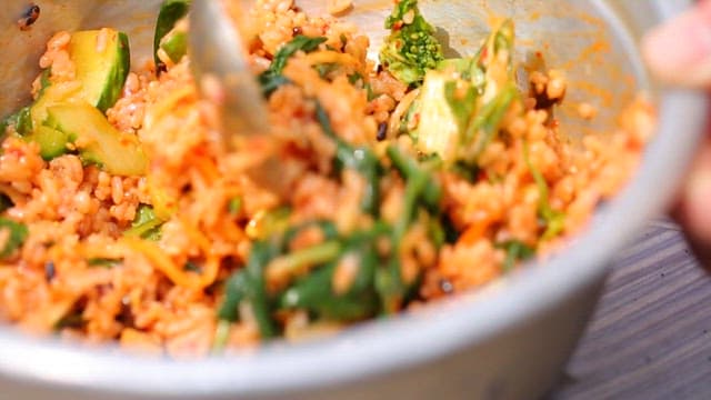 양푼에서 먹음직스러운 비빔밥을 숟가락으로 섞는 모습