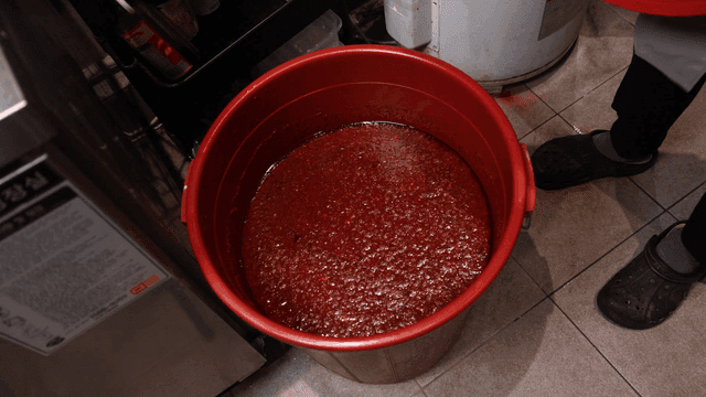 Opening a container of gochujang in a kitchen