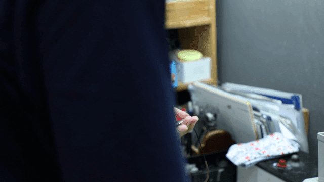 Person adjusting glasses in a workshop