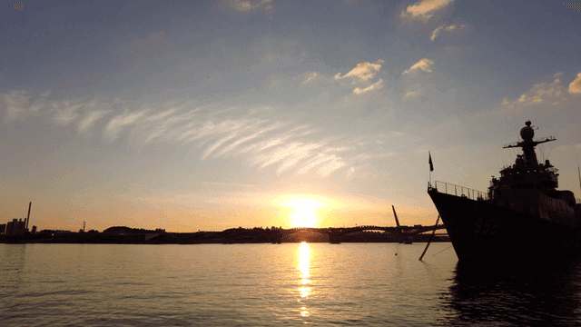 Boat on calm sea at sunset.