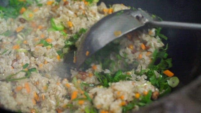 Vegetable fried rice being stirred in a pan