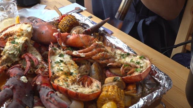 토치로 랍스터 위에 치즈를 녹이는 사람