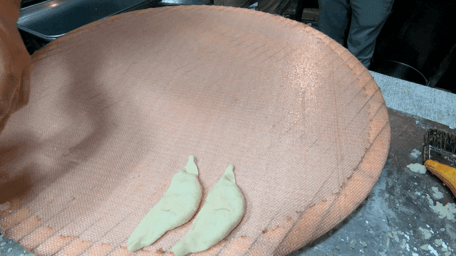 넓은 쟁반 위에 만두들을 가지런히 놓는 손