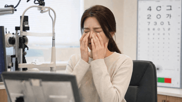 Woman rubbing her eyes in an eye clinic