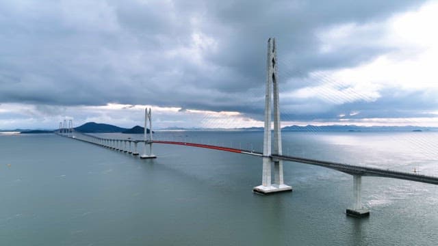 Long bridge over a calm sea under cloudy skies