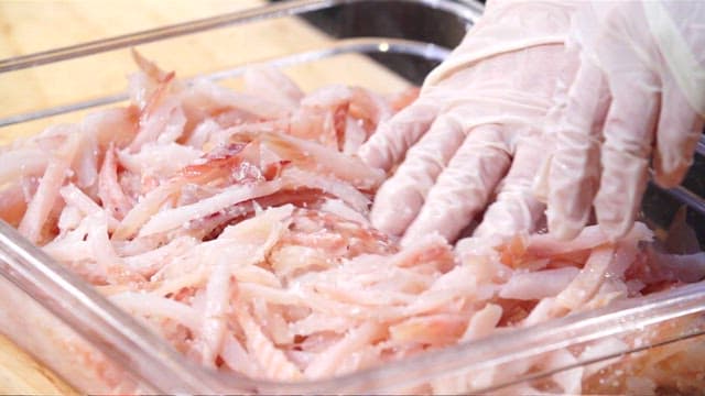 Chef preparing sliced raw pollack in a tray