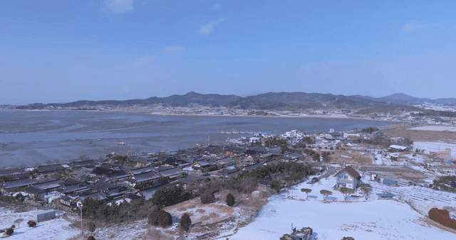 Snow-covered hanok village by sea