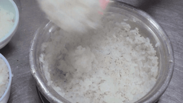 Steamed rice being served from a pot