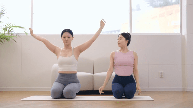 Yoga instructor guiding a student indoors