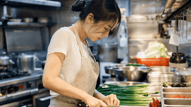 식당 주방에서 대파를 써는 여자