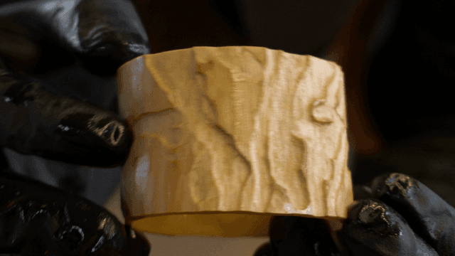 Gloved hand examining a piece of wood