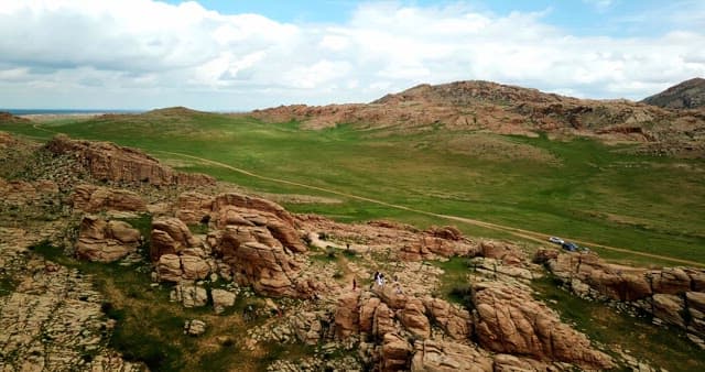 Expansive rocky landscape with green fields