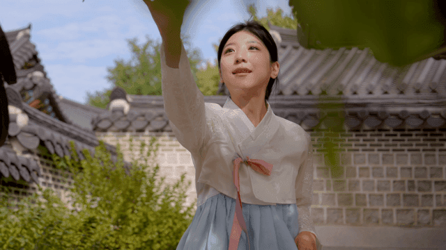 Woman in hanbok at a traditional Korean house