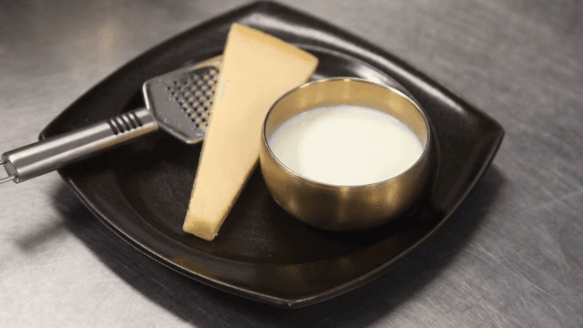 Cheese and milk on a black plate