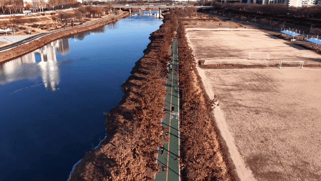 People jogging along a riverside path