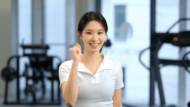 헬스장에서 정면을 보고 주먹을 모아 화이팅하는 젊은 여성