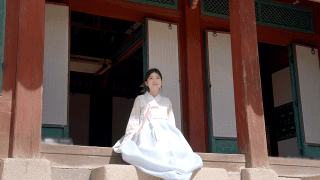 한옥에 앉아 있는 한복 입은 여성