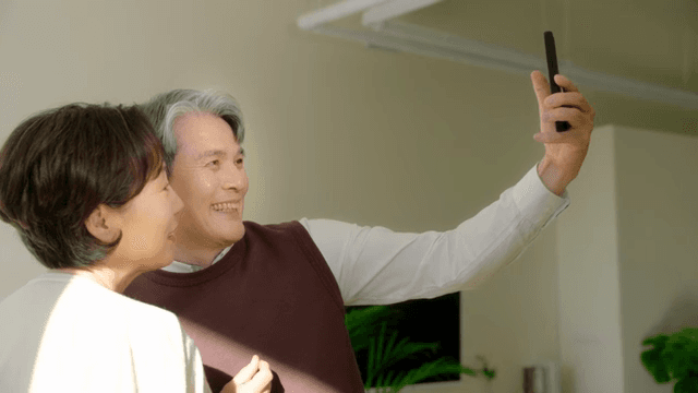 실내에서 셀카를 찍는 노부부