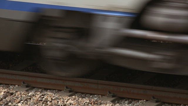 Wheels of a high-speed train running quickly on gravel tracks