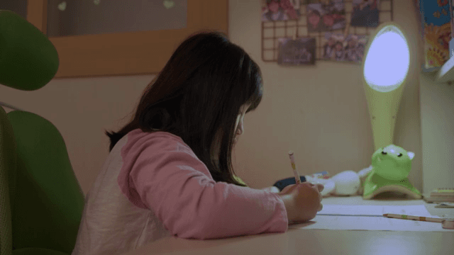 책상에서 집중하며 공부하는 아이