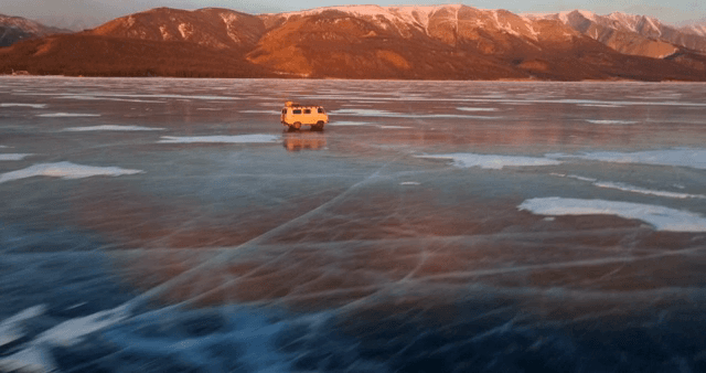 해질녘 얼어붙은 호수 위를 달리는 밴