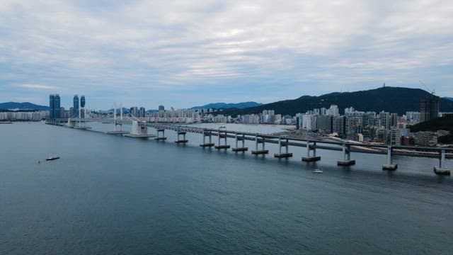 Long stretch of Gwangan Bridge and blue sea scenery on a cloudy day