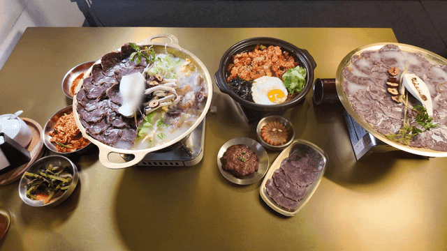 Full meal set on table featuring Hanwoo hot pot and stir-fried beef intestines