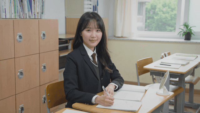 Female student smiling while sitting in the classroom