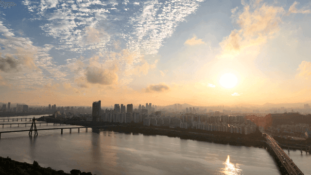 Sunrise over a city skyline with a river