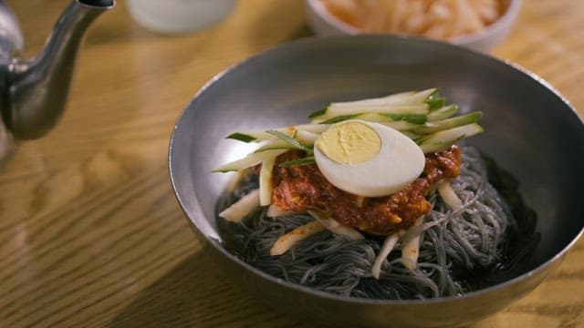 Cold noodles, Side Dishes and Chopsticks Set on the Table