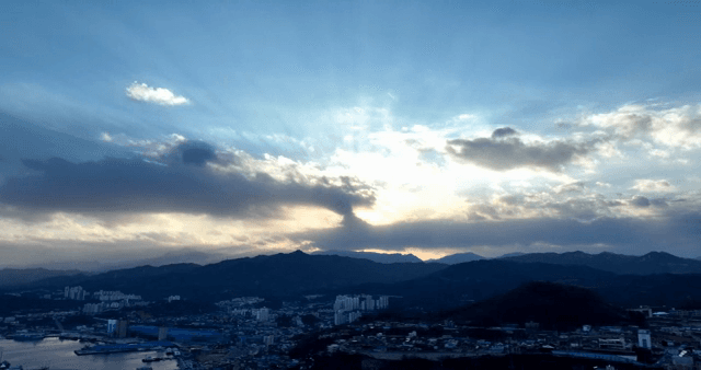 Cityscape with mountains and sunset sky