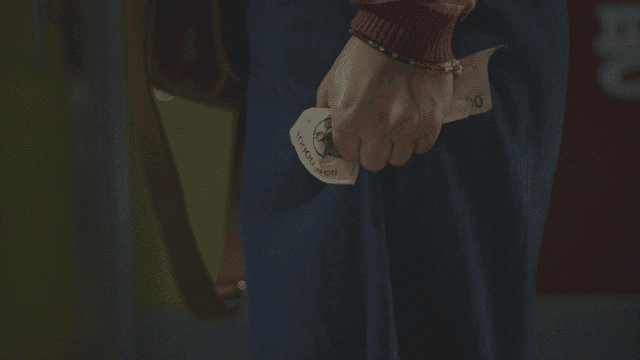 Hand tightly holding a ten-thousand won bill
