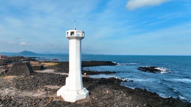 Lighthouse by the rocky seashore