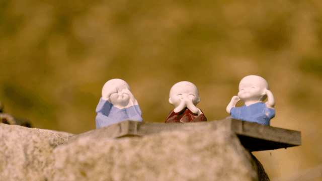 Three monk statues on stone