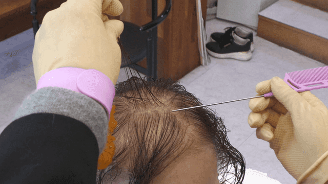 Hairdresser taking care of hair at beauty salon