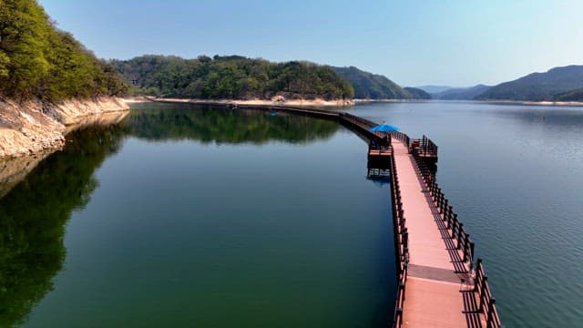 Serene lake with a long wooden walkway