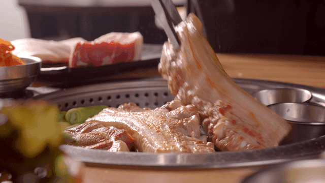Grilling pork belly on a tabletop grill