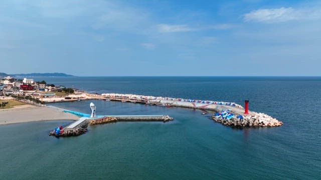 Coastal town with a lighthouse and breakwater