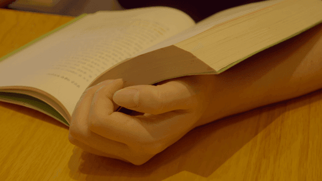 Person reading a book indoors