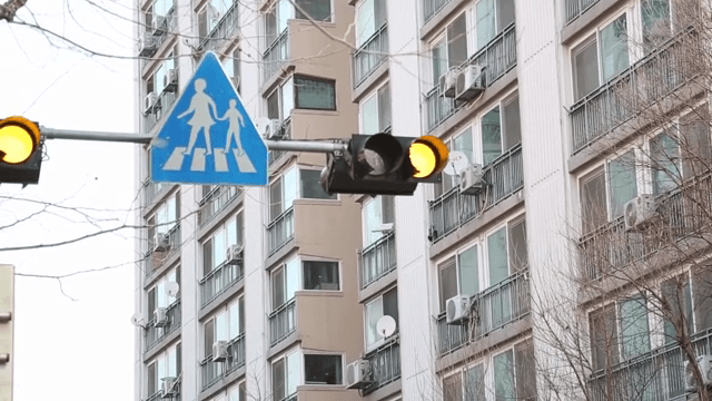 아파트 근처의 신호등과 보행자 표지판