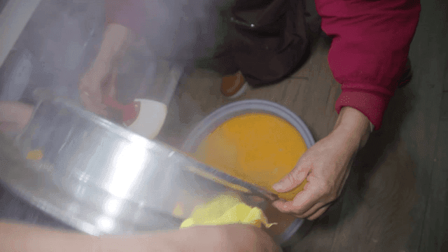 냄비의 호박죽을 다른 그릇에 붓는 모습