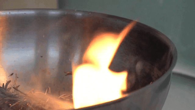 Burning rosemary herbs with flames in metal pan